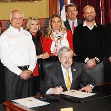 Iowa Governor Terry Branstad signs the 2014 Window Safety Day proclamation alongside the Geneser family.